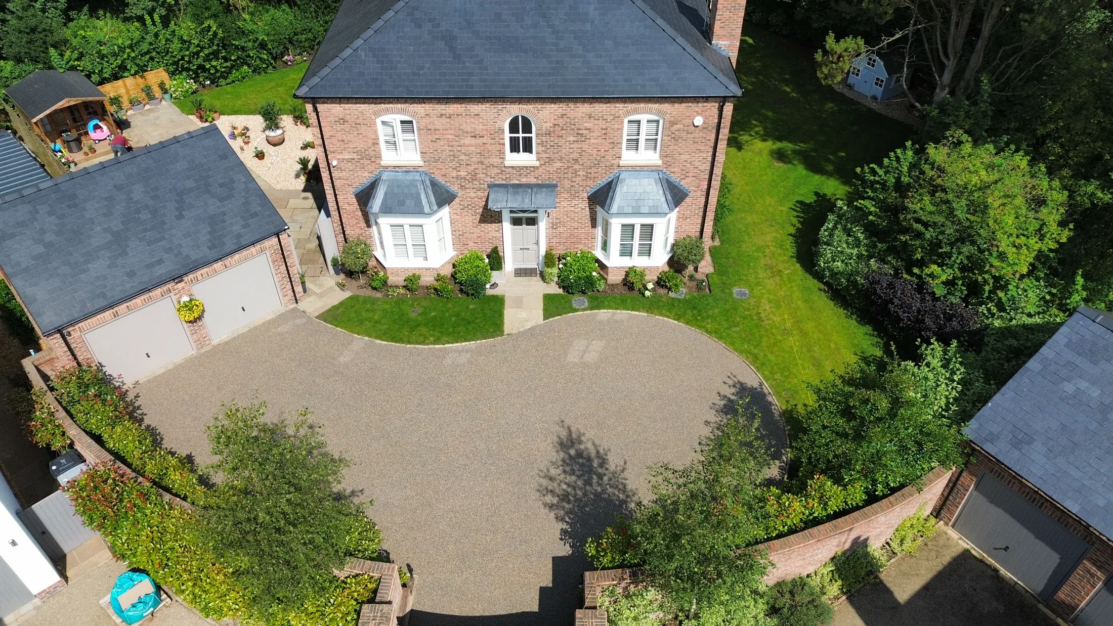 Aerial view of a large warm resin bound driveway curving around a Cheshire home